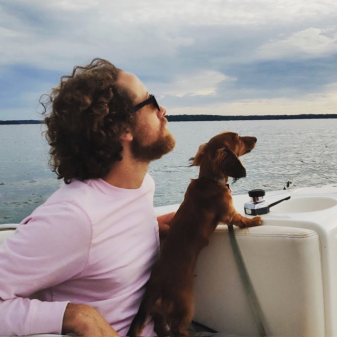 Dan Schuchman with a small dog looking out at the horizon